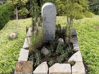 Urnengrab mit Brockeneinfassung aus Sandstein mit Stele in hellem Granit