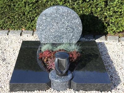 Mehrteilige Urnengrabplatte aus bicolor Granit mit integrierter Steinlampe und Grabstein in Kreisform